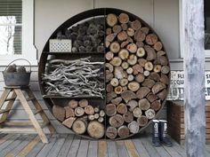 there are many logs stacked on top of each other in front of the door and behind it is a shelf with several different types of wood