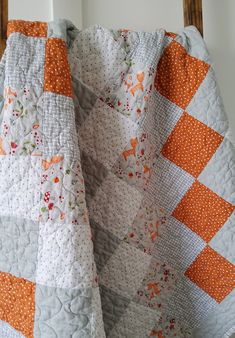 an orange and white quilt on a chair