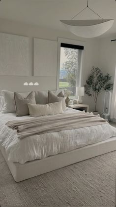 a large white bed sitting in a bedroom next to two lamps on either side of the bed