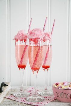 three glasses filled with pink liquid and topped with straws