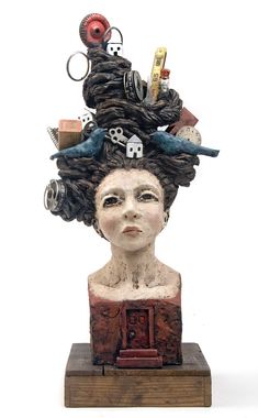 a busturine with many objects on it's head and hair in the shape of a woman's head