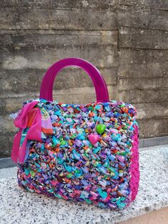 a colorful handbag sitting on top of a stone slab