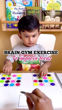 a little boy sitting at a table playing with a board game