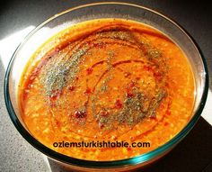 a glass bowl filled with red sauce and seasoning