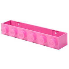 a pink plastic box with four knobs