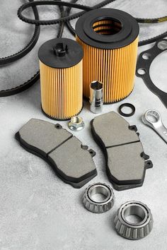 motorcycle parts including brake pads, oil filter and gasket on grey background with space for text