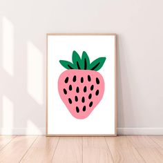 a pink strawberry with black dots on it is shown in front of a white wall