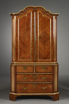 an antique wooden armoire with gold trimming