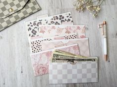 several different types of cards and envelopes on a wooden table next to a pen