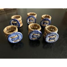 six small blue and white dishes sitting on top of a black table next to each other