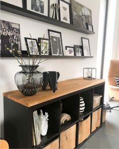 a shelf with some pictures and vases on it