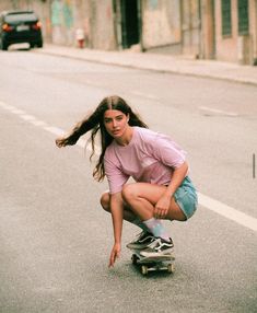 a young woman riding a skateboard down a street