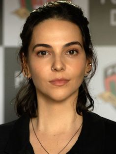 a close up of a person wearing a black shirt and necklace with an emblem on it