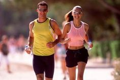 a man and woman running down a street