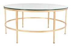 an oval glass table with gold metal legs