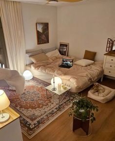 a living room filled with furniture and a laptop computer on top of a bed next to a window