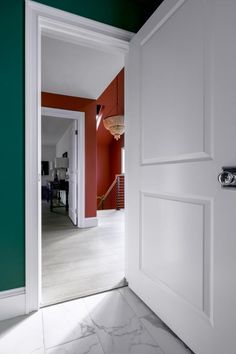 an open door leading to a room with red walls