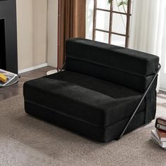 a black couch sitting in front of a fire place