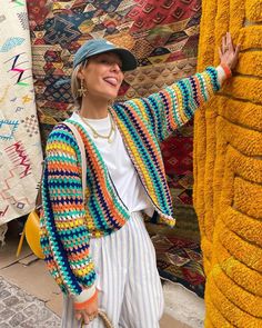 a woman standing next to a giant elephant statue in front of a quilt display at an outdoor market