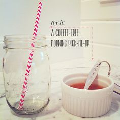 a glass jar filled with liquid next to a paper straw