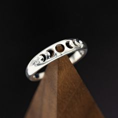 Product Details Ring Style: "Nera" is ahandcrafted, custom wedding ring featuring the phases of the moon with two diamond accents. This ring is pictured in silver. Width:The width of the ring pictured is approximately 5mm wide. Customizable:Because each ring is handcrafted to order, we can customize yours using unique materials, gemstones, or design features, often without any added cost! We can even use personal materials that you send! Basic customizations (material swaps, width changes, etc…) Cute Rings Silver Unique, Black Rings For Women, Spinner Rings Womens, Moon Phase Ring, Dragon Wedding, Wedding Forest, Custom Wedding Ring, The Phases Of The Moon, Astrology Jewelry