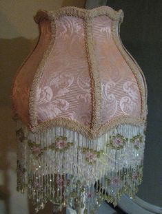 a pink lamp shade with beading on it