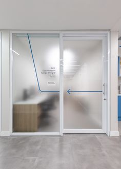 an empty room with glass doors and blue accents on the walls, leading to a staircase