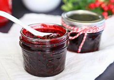 two jars filled with jam sitting on top of a table