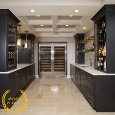 a large kitchen with black cabinets and white counter tops, along with an open wine cooler