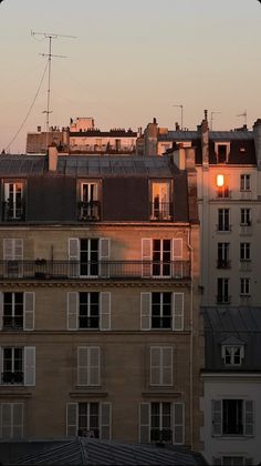 the sun is setting behind some buildings in paris