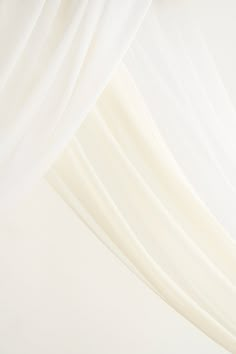 a white curtain is hanging from the ceiling in front of a light colored wall and floor