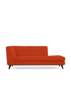 an orange couch sitting on top of a white floor