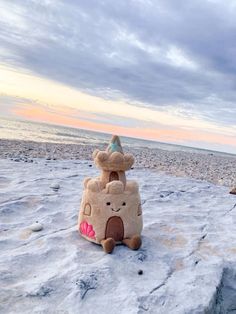 two stuffed animals sitting on top of an ice floet at the beach in winter