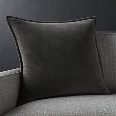 a black pillow sitting on top of a gray couch