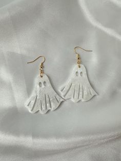 Grab a pair of these cutie ghost dangles to complete your look for spooky season! The simple silhouette makes these ghosts a perfect staple for everyday wear, and the resin ghosts are super lightweight so that you can wear them all day long!  (all earrings are gold-plated, hypoallergenic) All earrings are made to order, so please allow at least 3-5 days for your order to be completed and shipped. ---PRODUCT INFORMATION--- ☆ Items are handcrafted with love and care by me! ☆ Each item is uniquely crafted, the items you receive may not look exactly like the photos  ☆ Due to the nature of these handmade items, the final product may have minor imperfections/flaws; these will not interfere with the functionality of the product Minimalist Halloween, Sheet Ghost, Earrings Fall, Ghost Earrings, Earrings Halloween, Earrings Resin, Simple Silhouette, Halloween Earrings, Earrings Minimalist