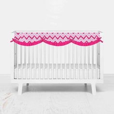 a baby crib with pink and white chevrons