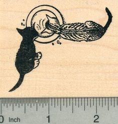 a rubber stamp with a cat and a bird on it's back, next to a ruler