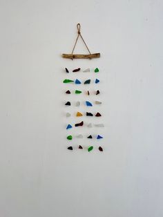 a piece of art hanging on a wall with colored glass pieces in the shape of arrows