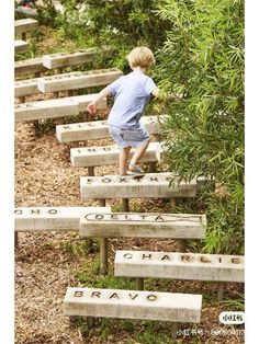 a little boy climbing up some concrete steps with words written on the stairs and trees in the background