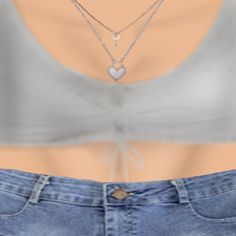 the back of a woman's shirt with two necklaces attached to her chest