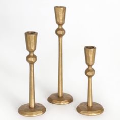 three brass candlesticks are standing next to each other