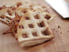 several waffles on a wooden table with a knife