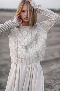 a woman in a white dress is holding her hair