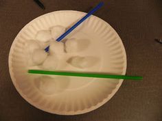 a paper plate with two chopsticks sticking out of it and ice in the middle