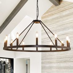 a chandelier hanging from the ceiling in a room with white walls and wood beams