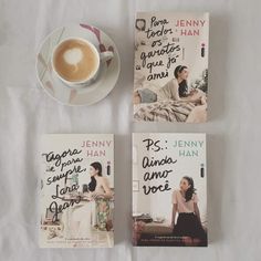 three books and a cup of coffee sitting on top of a white sheet next to each other