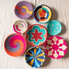 colorful baskets are arranged on a white surface