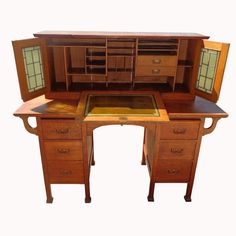 an antique desk with two drawers and a cabinet on the top, open to reveal its contents