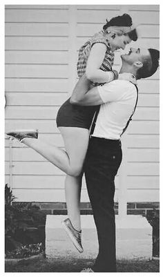 black and white photograph of a man holding a woman in the air with his legs crossed