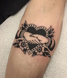 a black and white tattoo on the arm of a person with a heart shaped frame